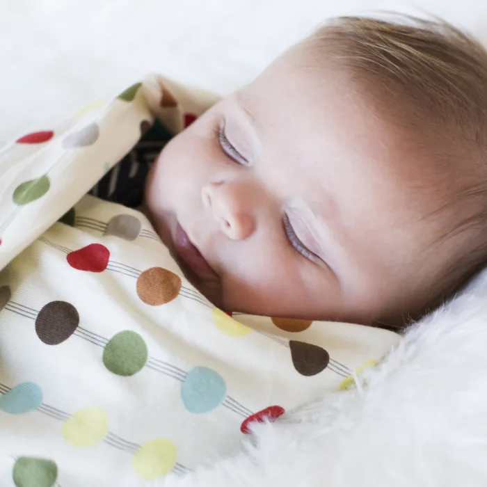 sleeping baby wrapped in a colorful blanket