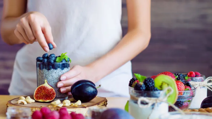 Person making a healthy snack of fruit and yogurt
