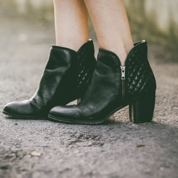 person wearing black boots standing on the road