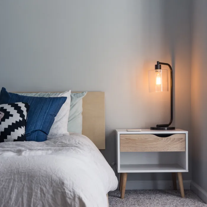 bed and side table lamp that is warmly lit